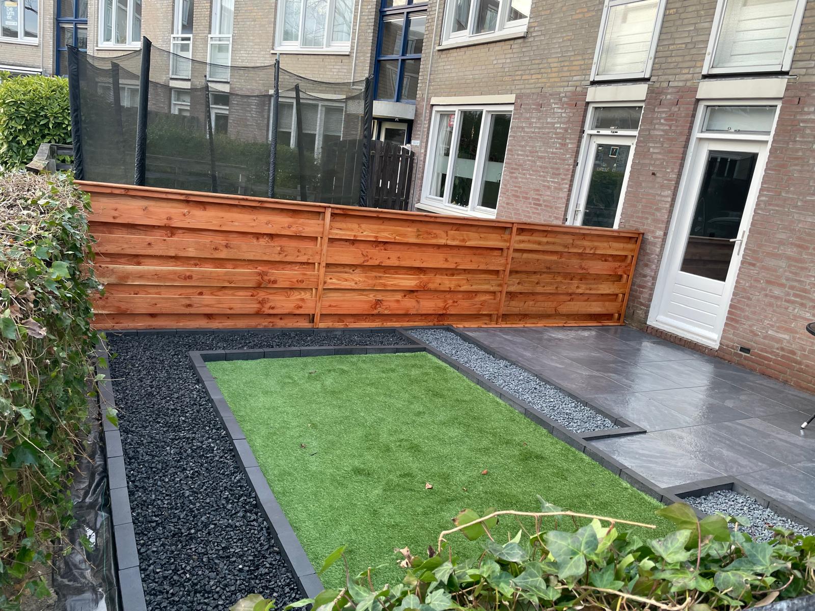 Tuinrenovatie met kunstgras, schutting en tegels